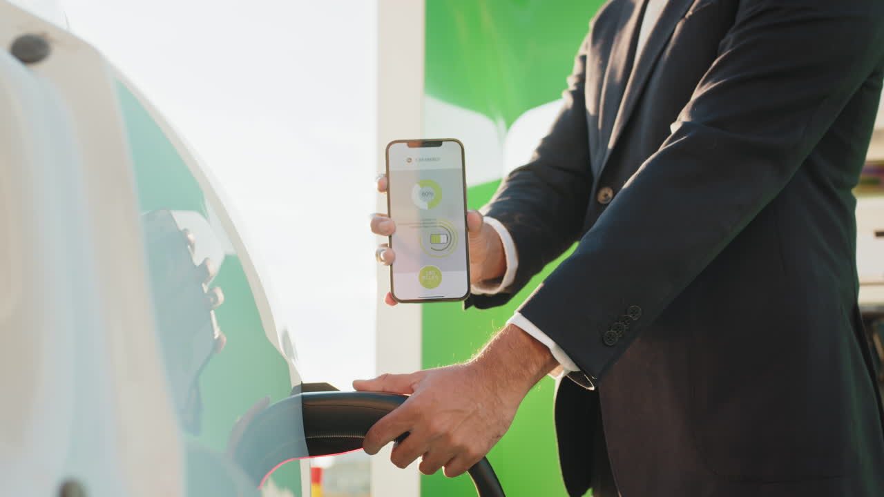 스마트폰 앱으로 전기 차량을 충전하는 남자