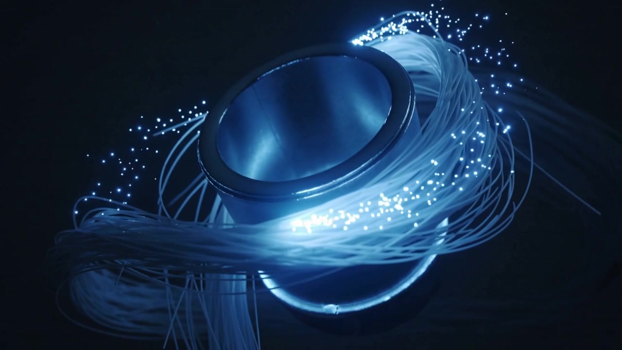 Pulsing light causing metal torus wrapped in fiber strands rotating in studio, emitting blue sparks