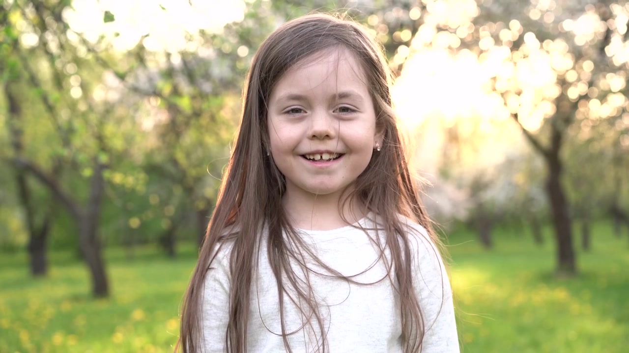 Menina feliz sorrindo em um jardim ensolarado de primavera