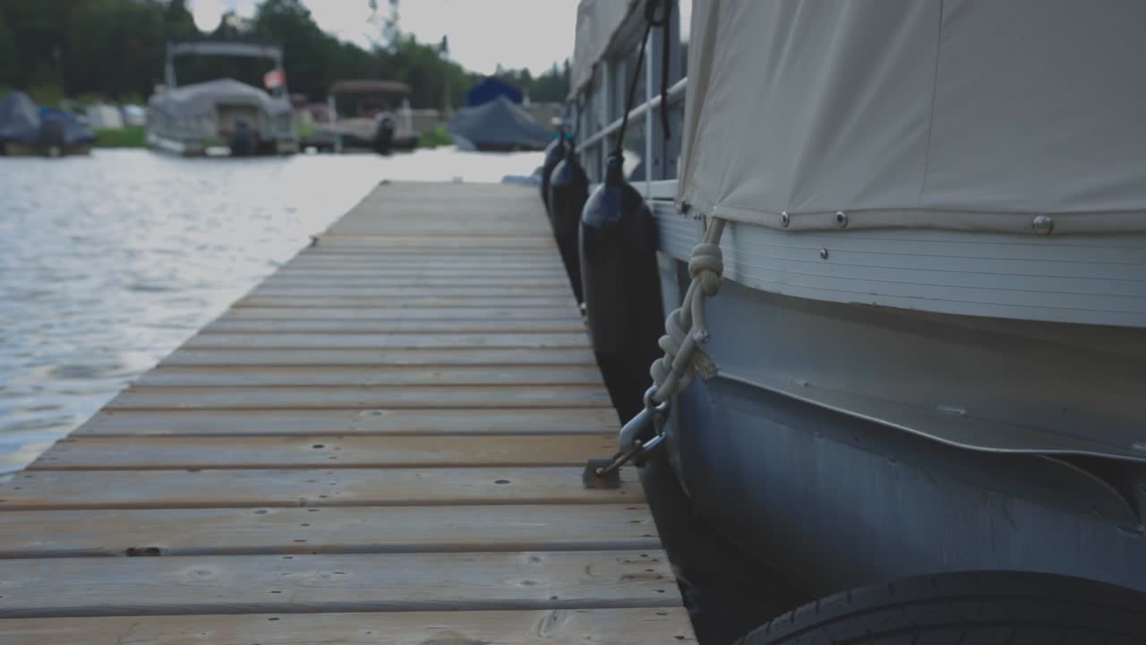 Hull Of Boat Moored On The Wooden Jetty And Floating On The Calm Water. - medium shot