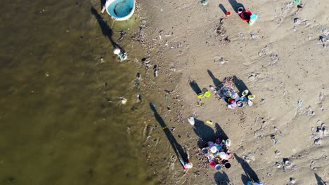 Vietnamese-extracting-resources-from-sea,-plastic-bags-on-beach