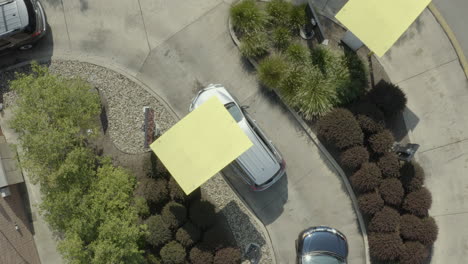 drone aerial flyover of cars in line at a fast food restaurant drive thru during covid pandemic