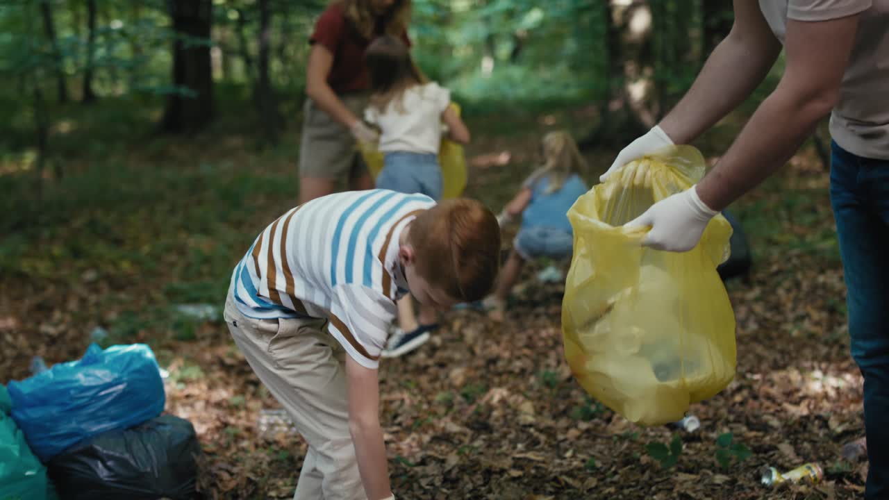 Caucasian boy cleaning forest from trashes with family.