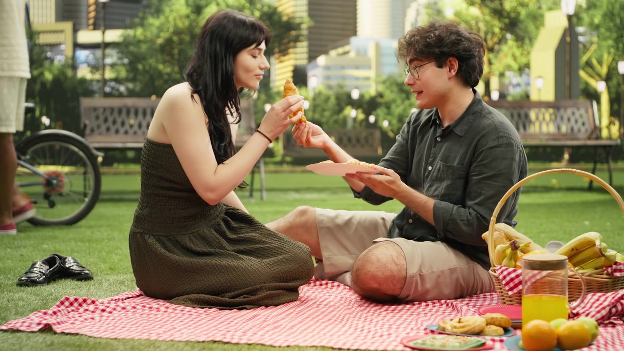 Young couple enjoying playful intimate moment as man offers woman croissant bite