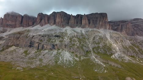 rock formation in the dolomite mountain area in northern italy on an overcast cloudy winter day, aerial drone reveal shot