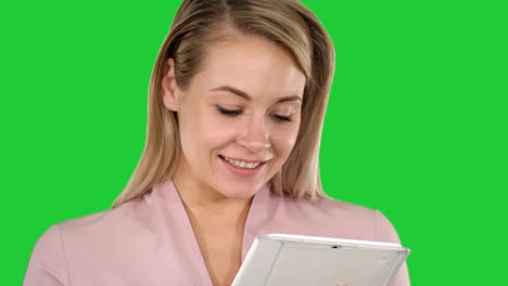 mujer de negocios activa sosteniendo una tableta en una pantalla verde, clave de croma