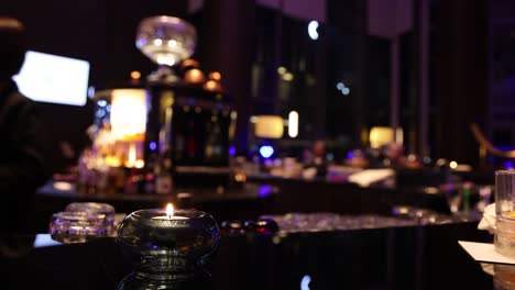 dimly lit bar with patrons and candles