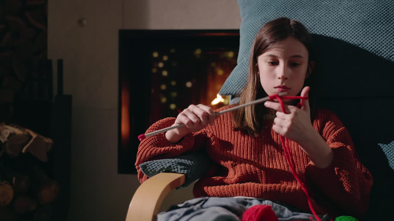 벽난로 에서 뜨개질하는 소녀