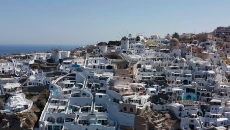 coastal town of oia on the northwestern tip of santorini, a greek aegean island - aerial drone shot