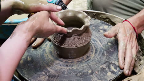 potter creates a pitcher on a pottery wheel