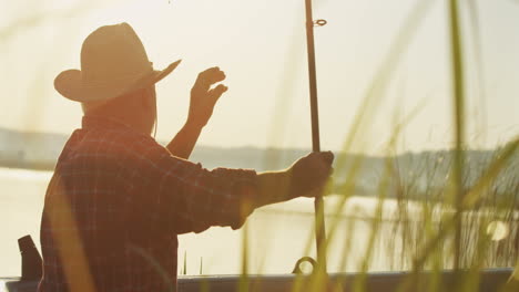 close-up view of caucasian senior man fishing on a boat in the lake on a cloudy morning