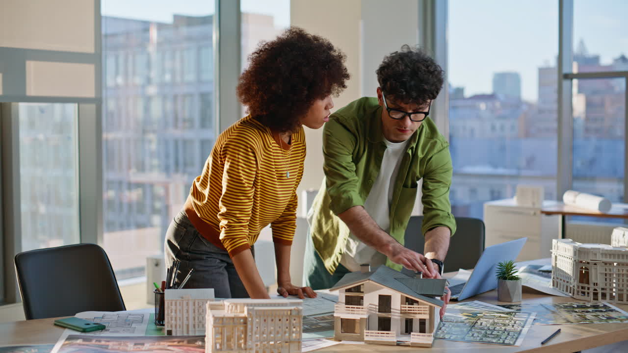 Property managers working building layout at office desk. Two contractors