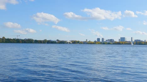 big lake in sunny weather with skyscrapers in the distance