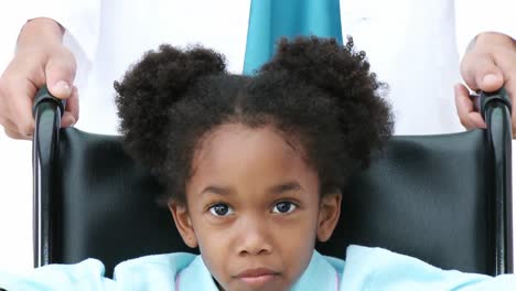 portrait of ethnic little girl sitting on wheelchair