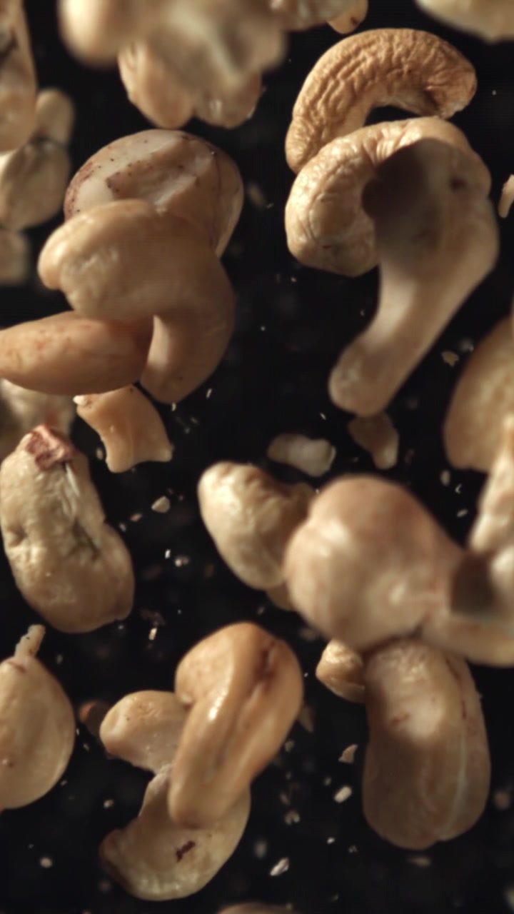 Cashew Nuts Falling in Slow Motion Against a Dark Background
