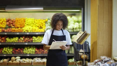 African-american-female-staff-person-standing-with-tablet-in-supermarket