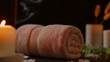 still life of lit candles with scattered petals incense stick and soft towels against dark background as part of relaxing spa day decor 1