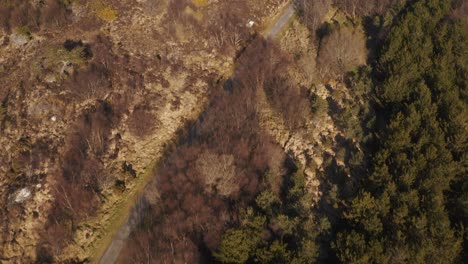 Drone-tilt-shot-revealing-the-town-of-Stornoway-and-the-landscape-beyond-it-on-a-sunny-day-on-the-Isle-of-Lewis,-Outer-Hebrides-of-Scotland,-United-Kingdom