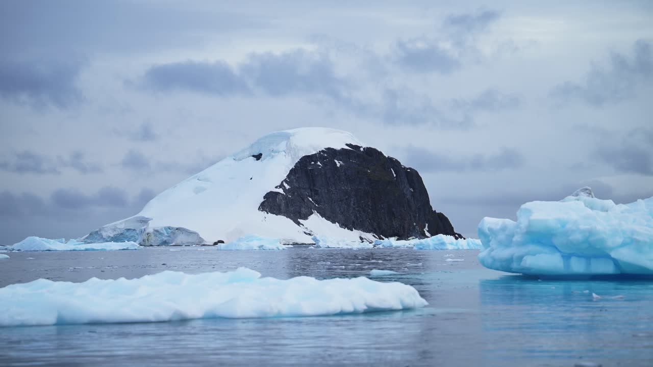 Calentamiento global y cambio climático con deshielo y calentamiento del océano en la Antártida, montañas y paisaje invernal en la Península Antártica en una hermosa y dramática escena costera