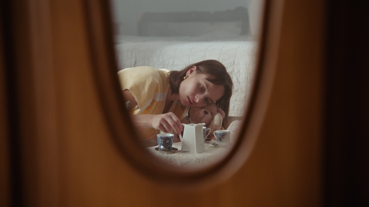 A girl playing with dolls in her room