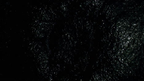 slow moving sparkly circular shape as it moves both outwards and inwards quickly at first and then slowly—looking like a black hole