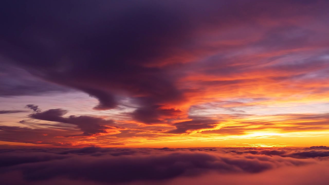 Stunning sunset view above the clouds with vibrant purple sky