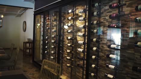 una toma dentro de un restaurante con un armario de vino de lujo, girando lentamente hacia la derecha, mostrando una atmósfera elegante y sofisticada