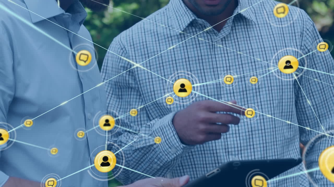 animación de una red de iconos digitales sobre la sección media de dos hombres discutiendo sobre una tableta en un parque