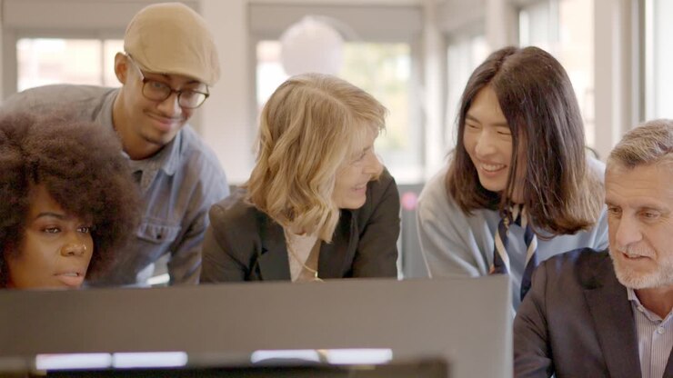 Coworking team discussing a project looking at computer together