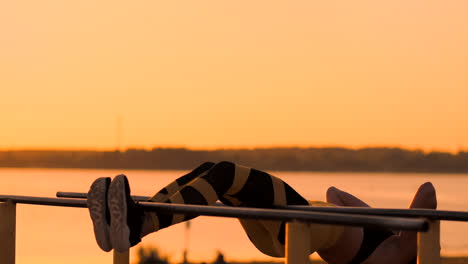 Offene-Aufnahme-Einer-Wirklich-Gesunden-Und-Fitten-Frau,-Die-Bei-Sonnenuntergang-An-Der-Strandpromenade-Hängende-Beinheben-Auf-Einer-Outdoor-Fitnessstation-Durchführt.-Zeigt-Einen-Starken-Bauch-Sixpack.