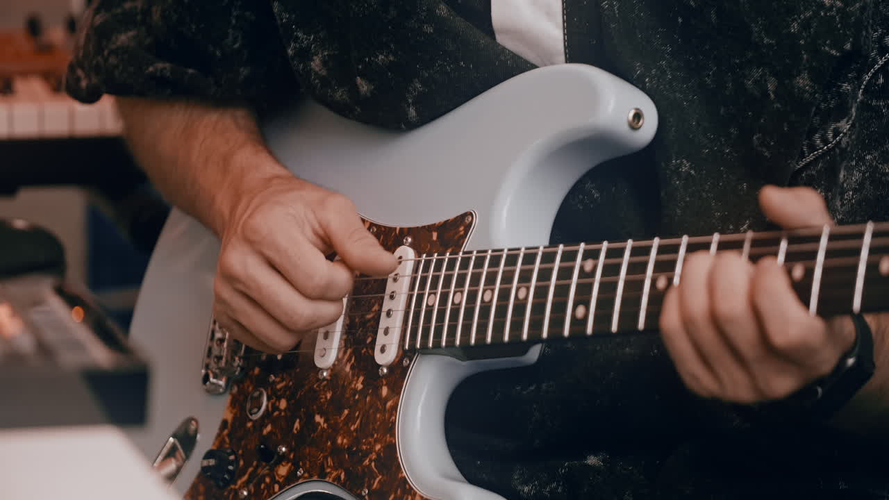 Person Playing an Electric Guitar in a Recording Studio