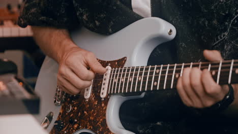 person playing an electric guitar in a recording studio