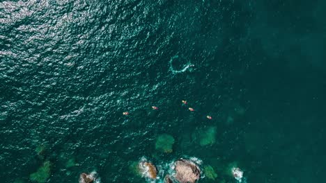 aerial footage of kayakers paddling through deep blue waters, showcasing the thrill of adventure and exploration in the open sea