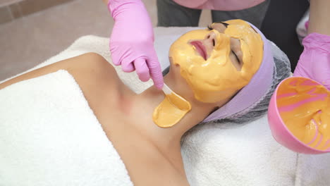 cosmetologist applying facial mask in beauty salon. skin care. beauty treatment. beautiful woman with facial mask at beauty salon.