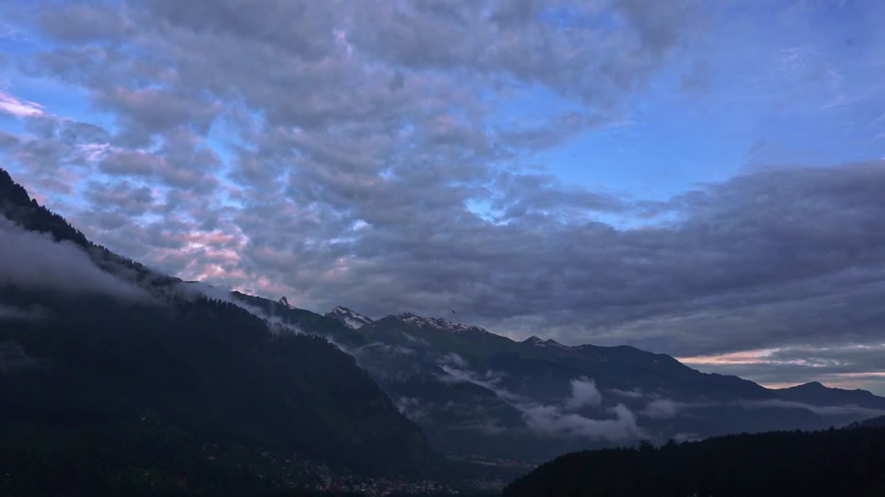 A panaromic shot of a valley in manali during sunset .