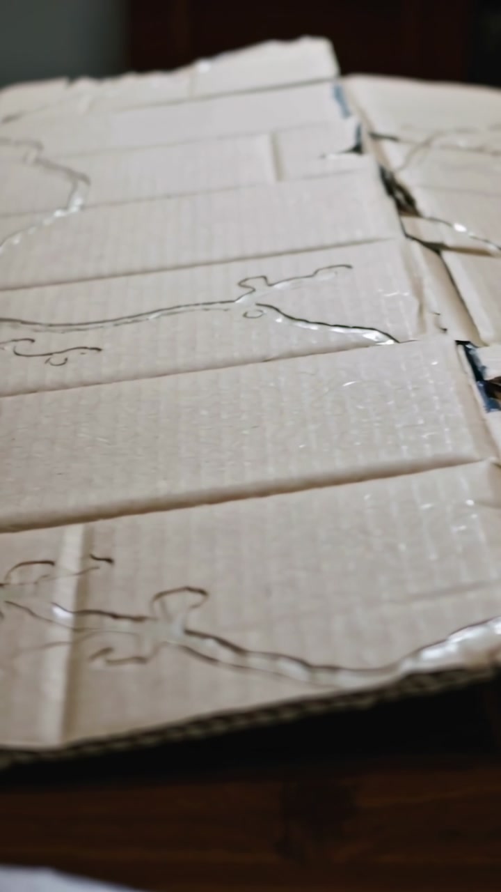 Vertical video: Drifting camera showing ribbed cardboard sheet on table, highlighting glue patterns