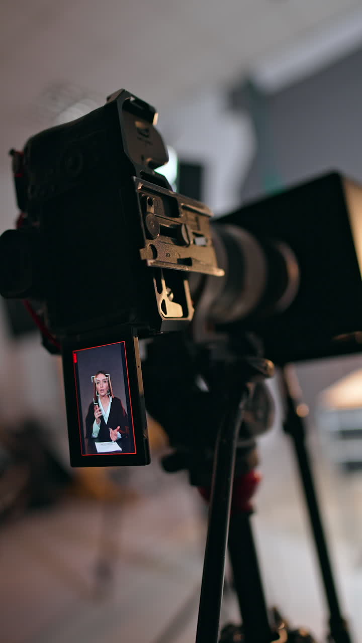 Display of a modern camera depicts a Caucasian lady. Close up. Blogger talks and waves her hands. Vertical video