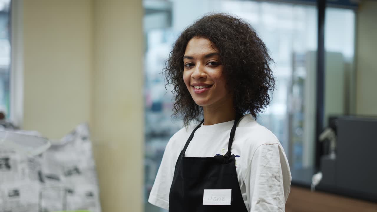 retrato de um trabalhador afro-americano na caixa da mercearia, sorrindo amigável para a câmera
