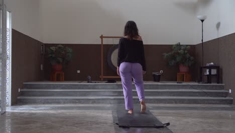 chica hacer yoga en la sala de meditación con un gran gong