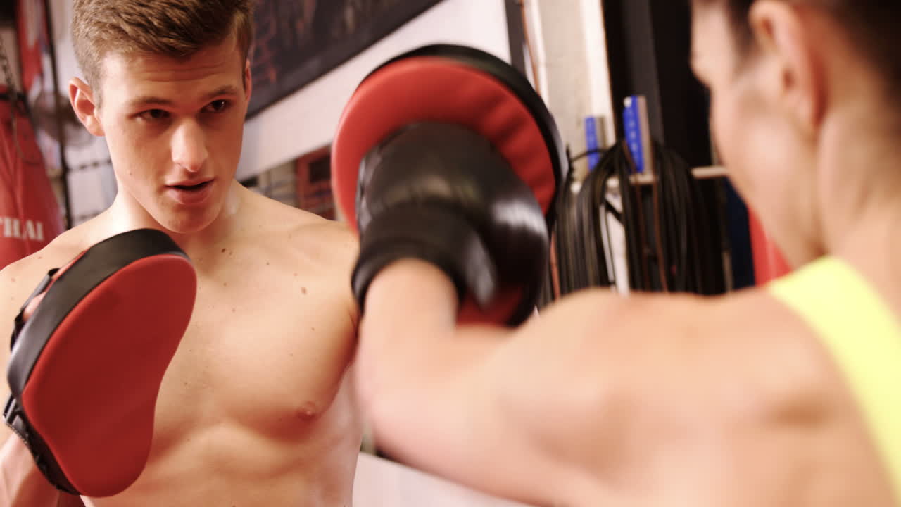 여자 권투 선수 가 트레이너 와 함께 연습 하고 있다