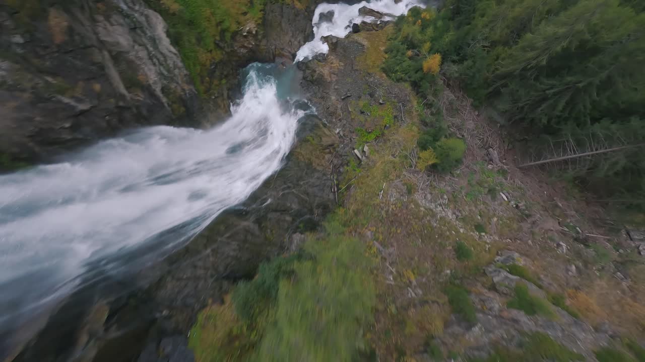 A breathtaking slow-motion FPV dive down a waterfall nestled in the picturesque Austrian Alps, surrounded by lush greenery