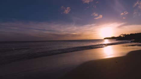 persona nadando en estilo libre en una playa apartada en el oeste de maui con una hermosa puesta de sol hawaiana en el fondo