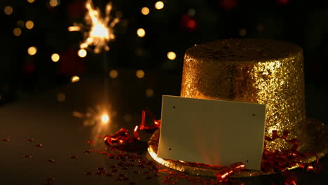 sparkler beside a golden hat and card