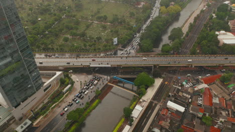 Aerial-view-of-busy-car-intersection-with-passing-and-stopped-cars-in-Jakarta,-Indonesia