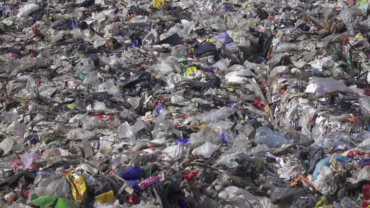 Zoom out from plastic waste in a dumping ground
