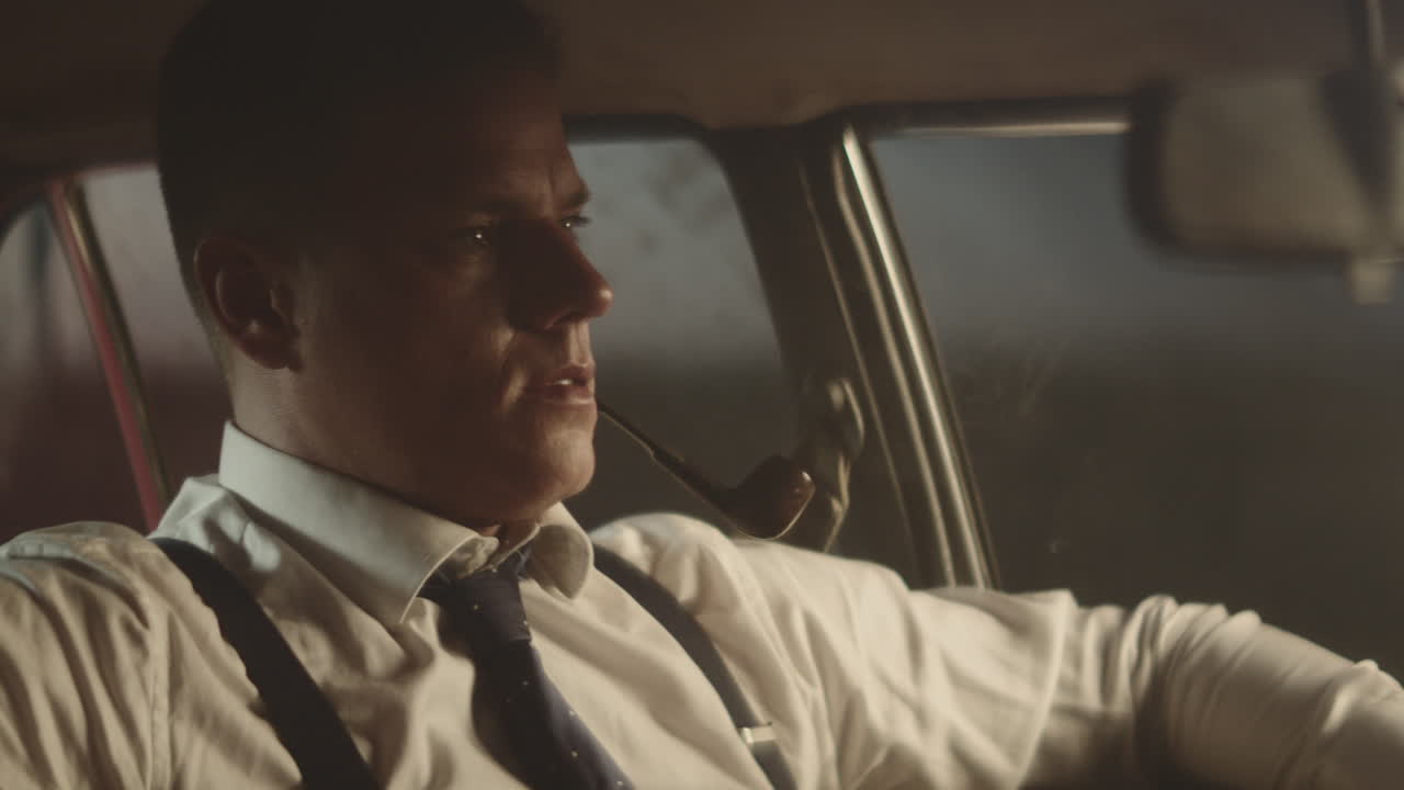 빈티지 자동차 에서 파이프 를 피우는 남자