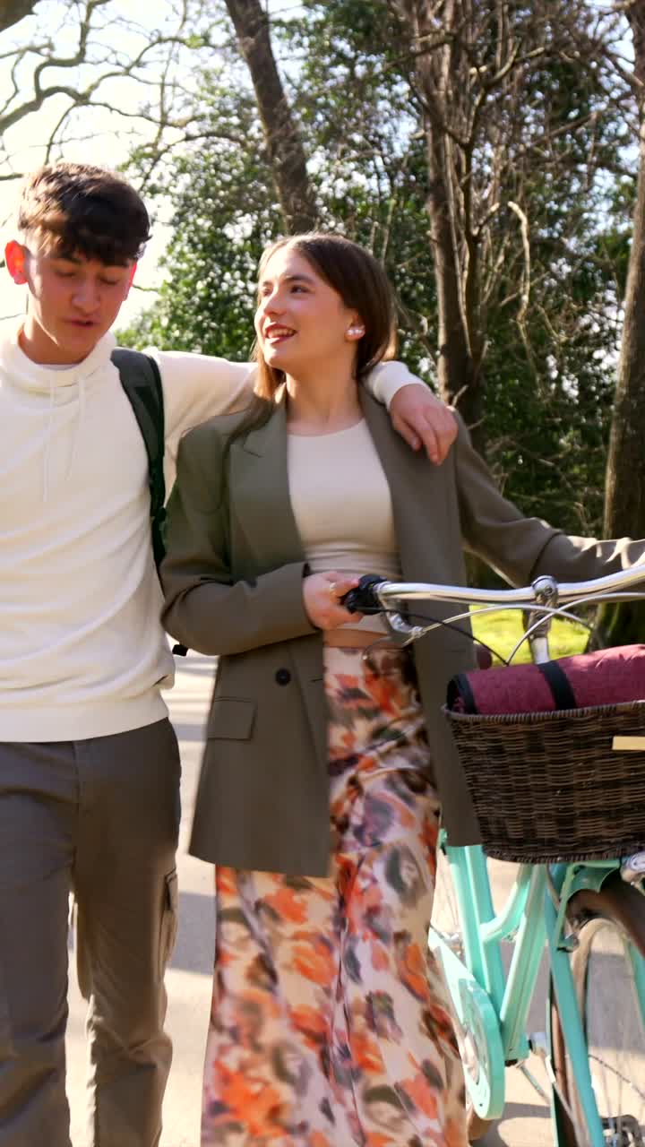 Couple walking with bicycle in park
