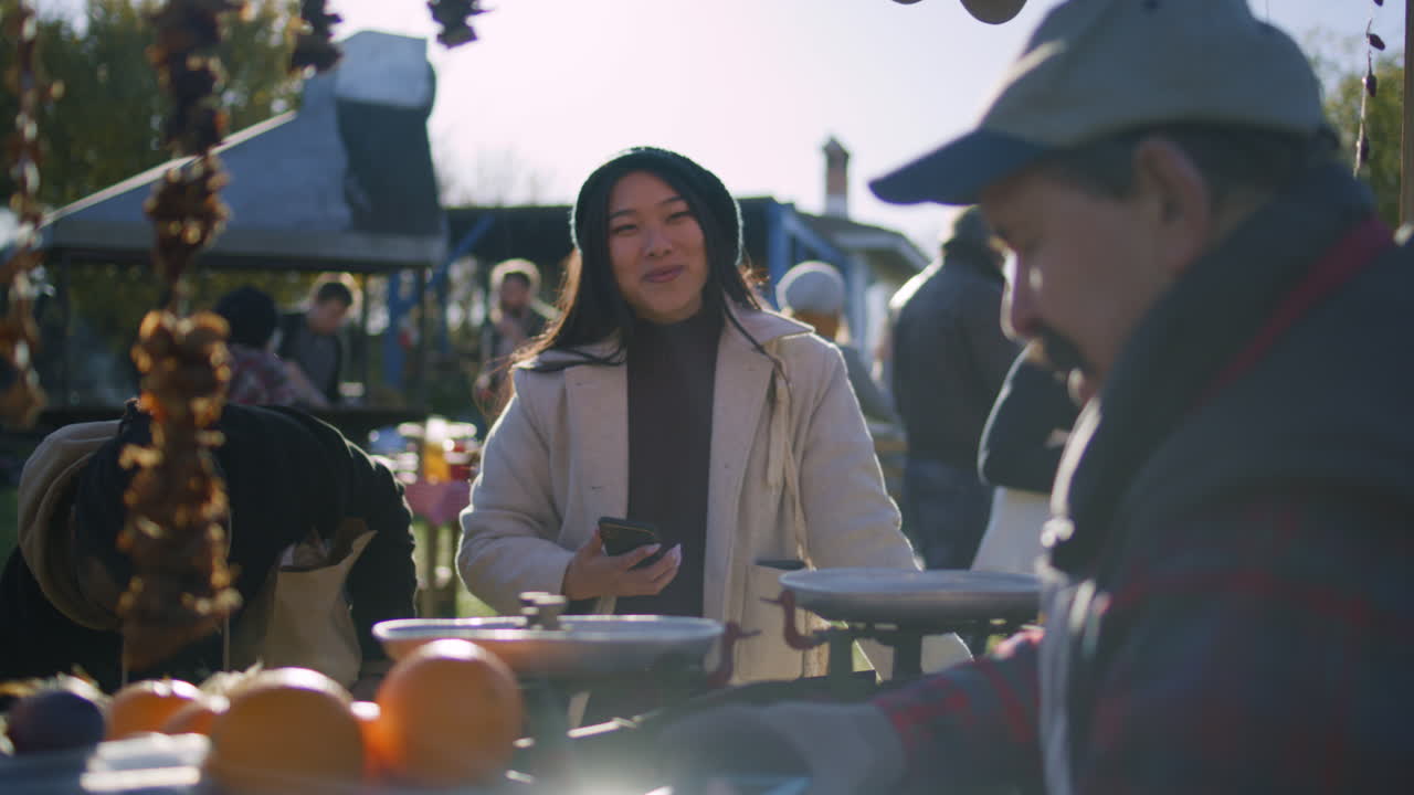 Woman Paying for Produce at an Outdoor Market