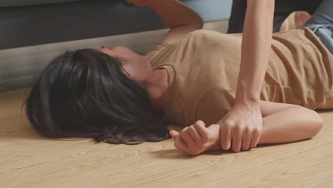 close up of young asian woman victim of violence with bruise on body being held hands and raped by a man on the floor at home