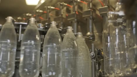 automatic filling machine pours water into plastic pet bottles at modern beverage plant